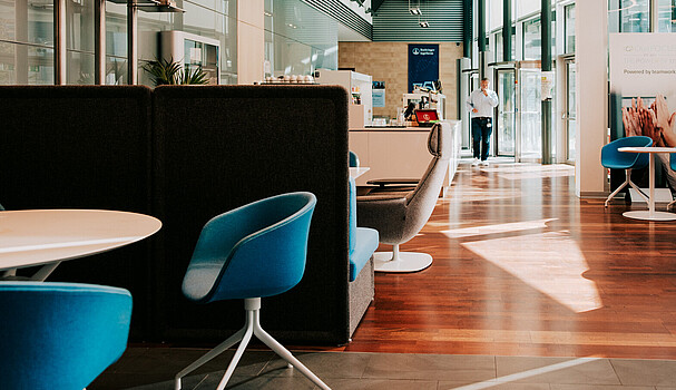 An empty coworking space with blue chairs on a sunny day
