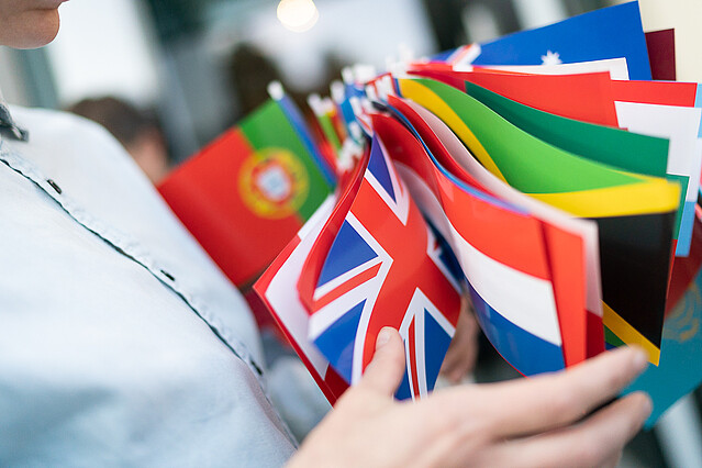 Someone holding a bunch of flags of different countries