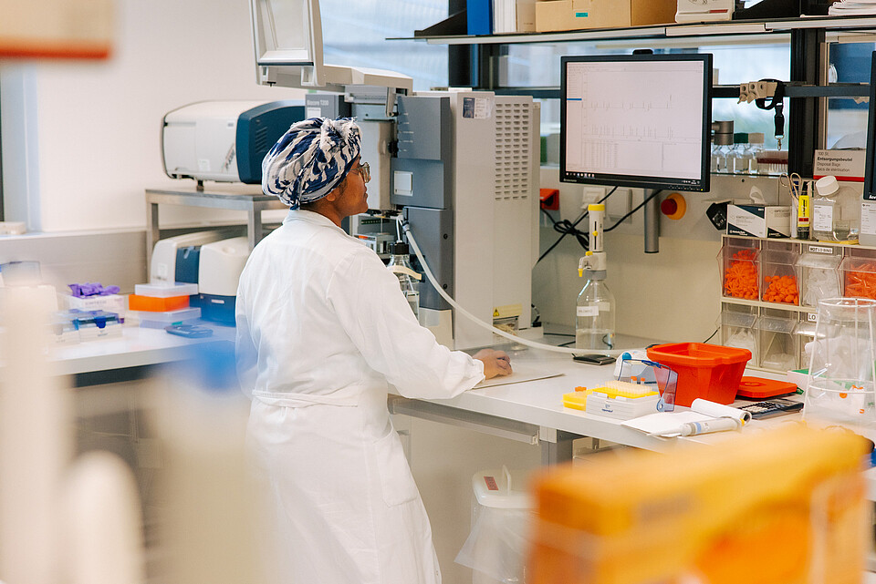 A female scientist working at a computer in a lab.