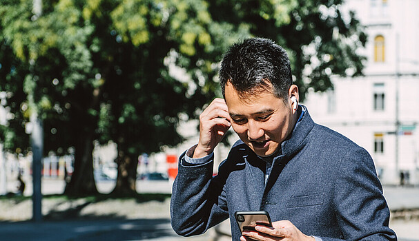 Man dressed in business attire with phone at Schwarzenbergplatz