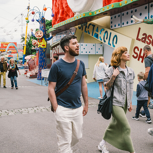 Three young people a man and two women walking into the amusement park Wiener Prater